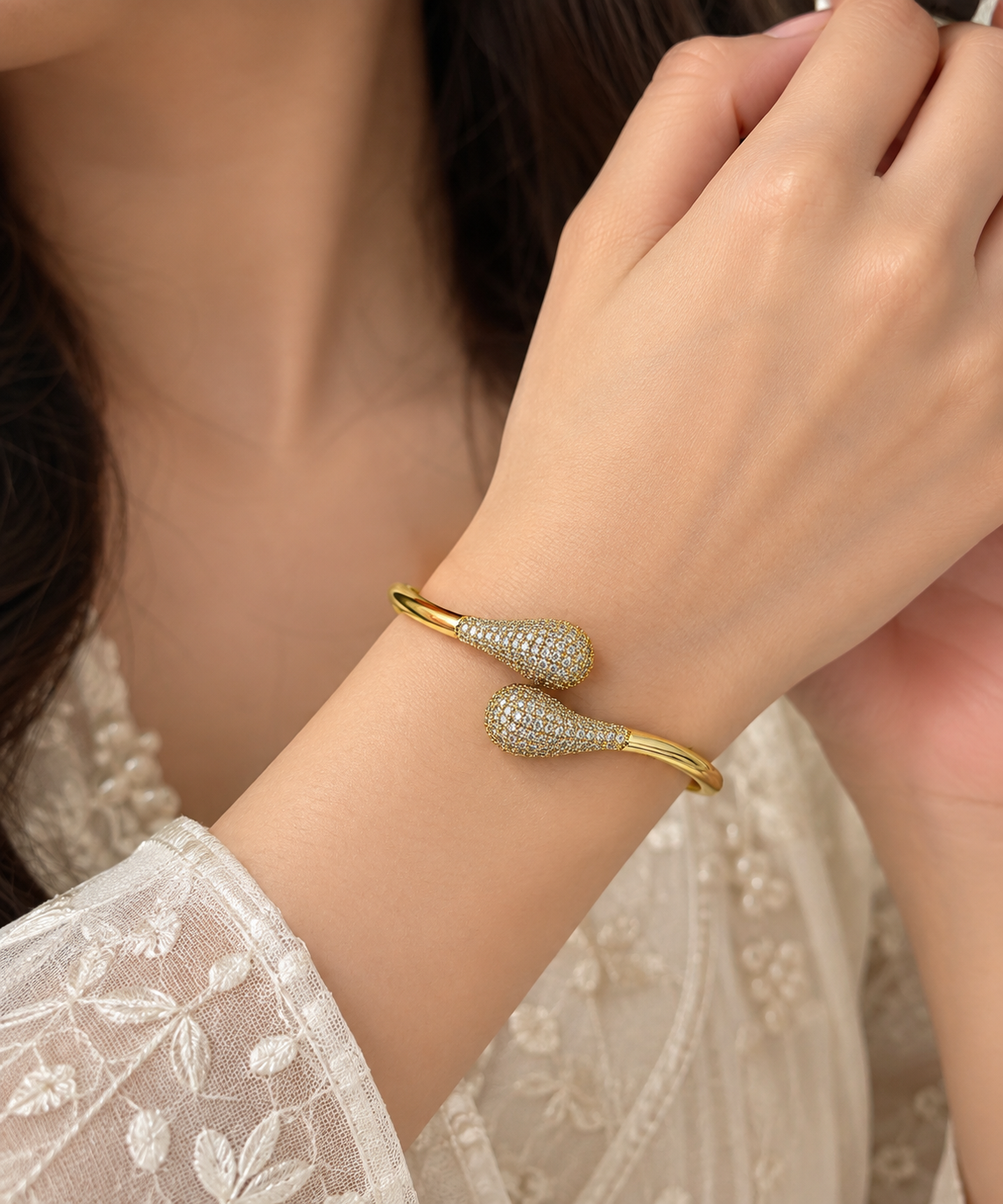 Anti tarnish ,this elegant Gold Tone Crystal Pave Open Cuff Bangle. Designed with a sleek open-cuff silhouette and beautifully detailed teardrop-shaped ends, this statement bracelet combines a polished gold-tone finish with sparkling crystal-style stone