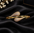 Anti tarnish ,this elegant Gold Tone Crystal Pave Open Cuff Bangle. Designed with a sleek open-cuff silhouette and beautifully detailed teardrop-shaped ends, this statement bracelet combines a polished gold-tone finish with sparkling crystal-style stone